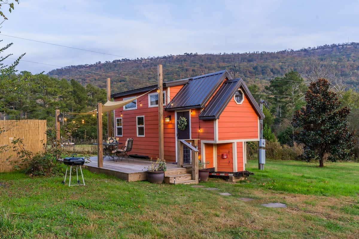 The red tiny home and its deck, with Lookout Mountain behind