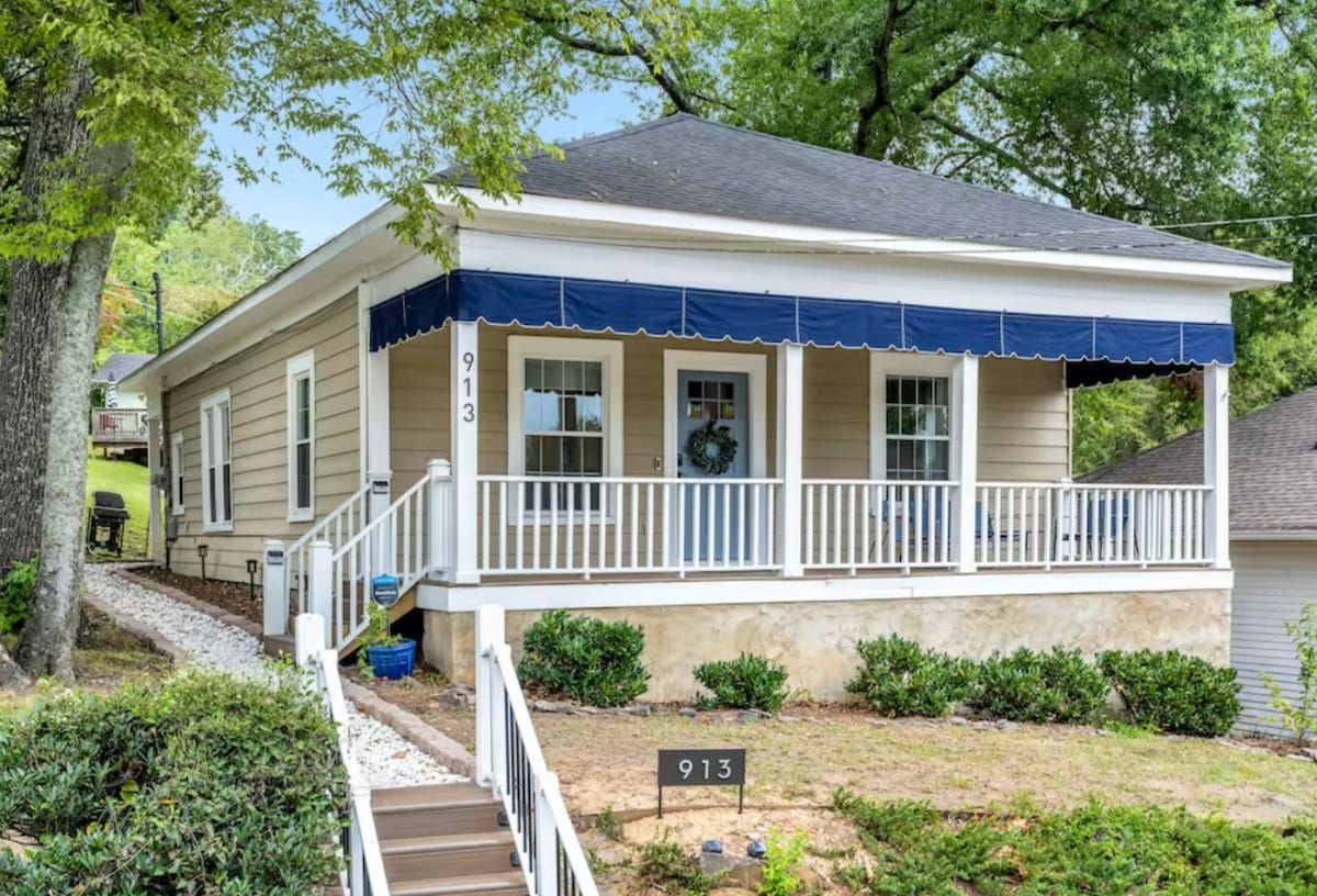 The tan bungalow with a blue awning over its front porch