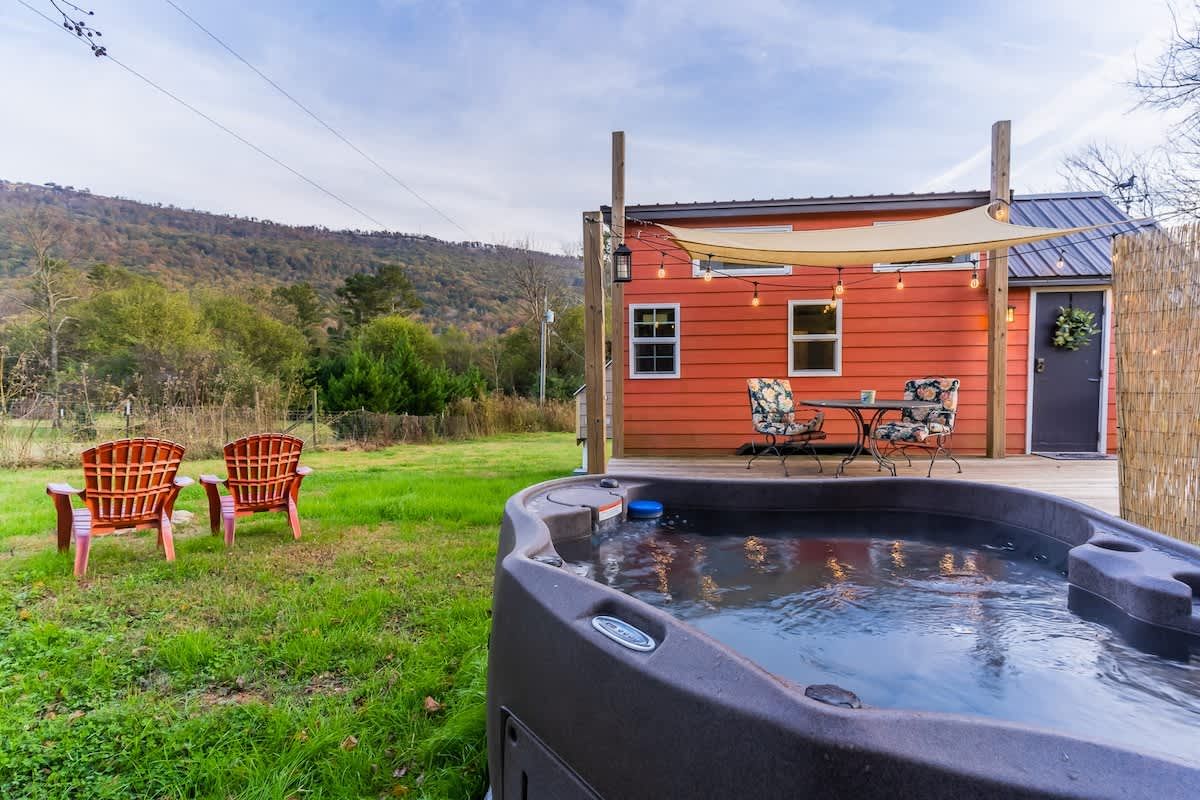 Hot tub with chairs and the tiny home beyond