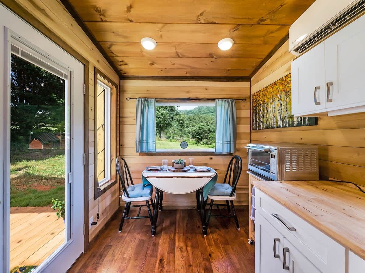 Wood-lined kitchen with a small dining table by the window