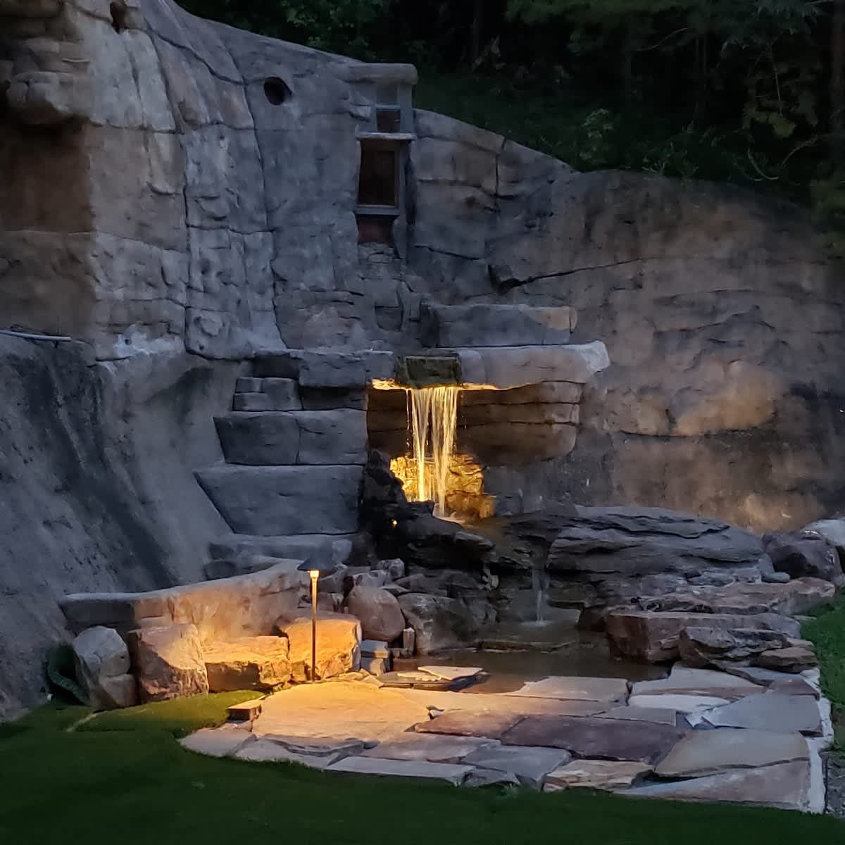 Water running down stone steps, lit at night