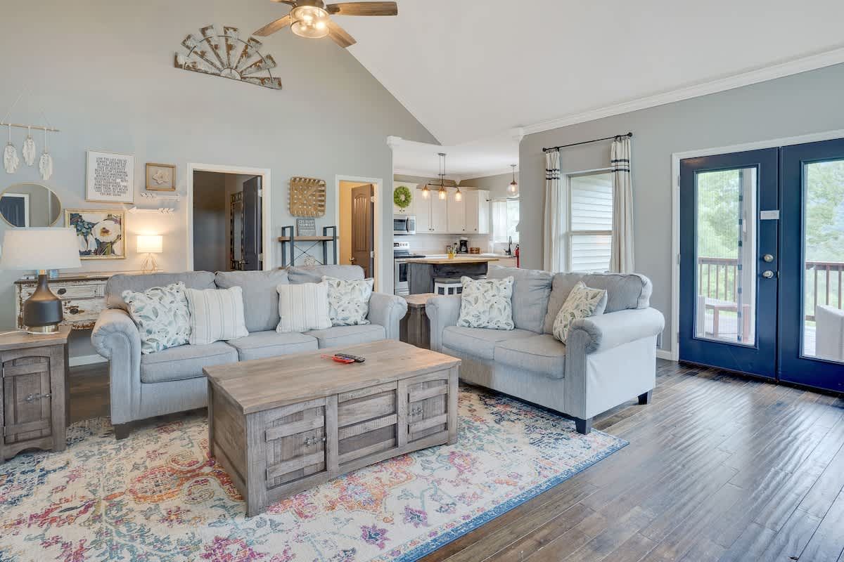 Bright living room with white sofas and a vaulted ceiling