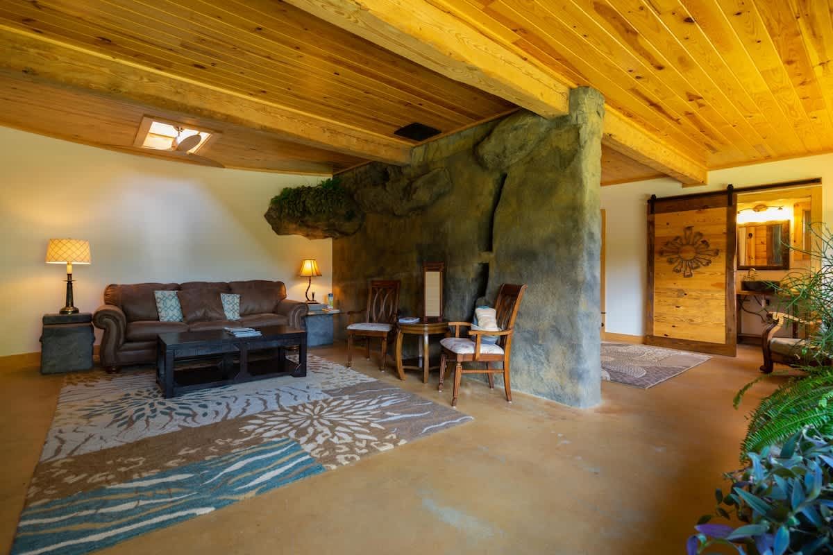 Living room with a leather sofa beside the carved stone wall