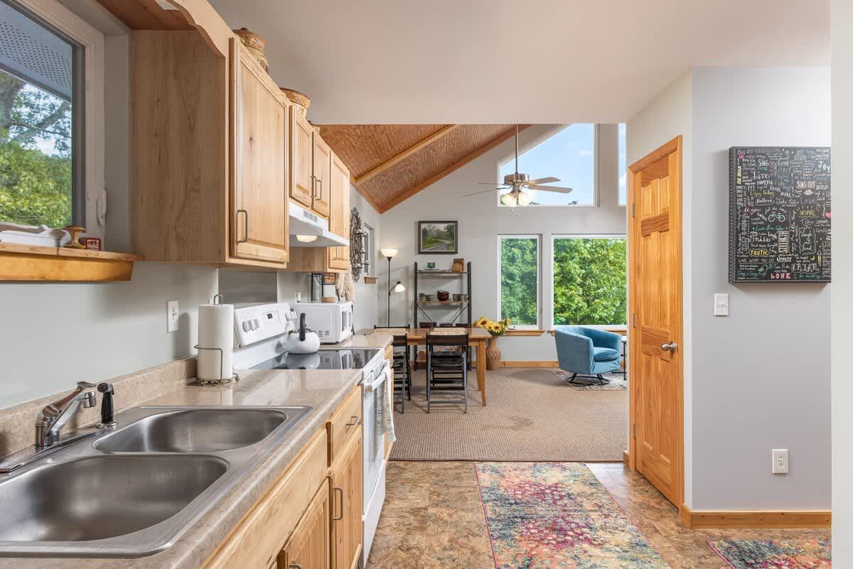 Kitchen with wood cabinets and a window to the trees