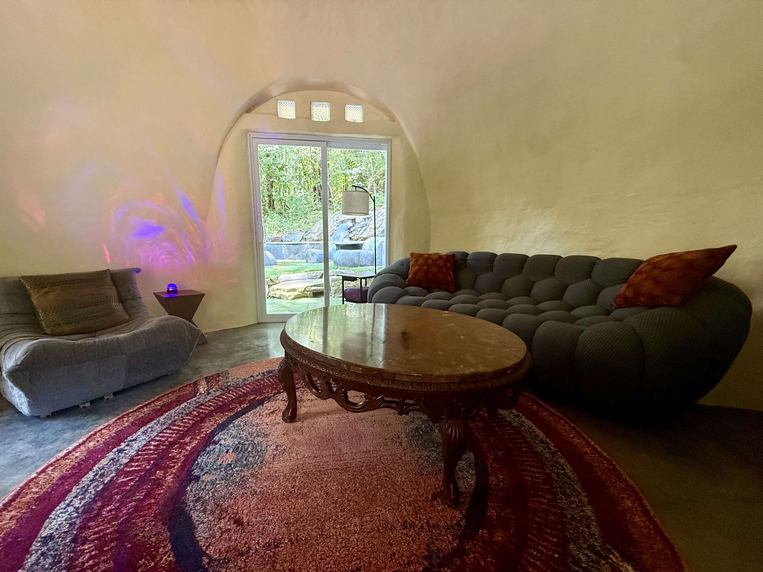 Round living room with a curved sofa and a patterned rug