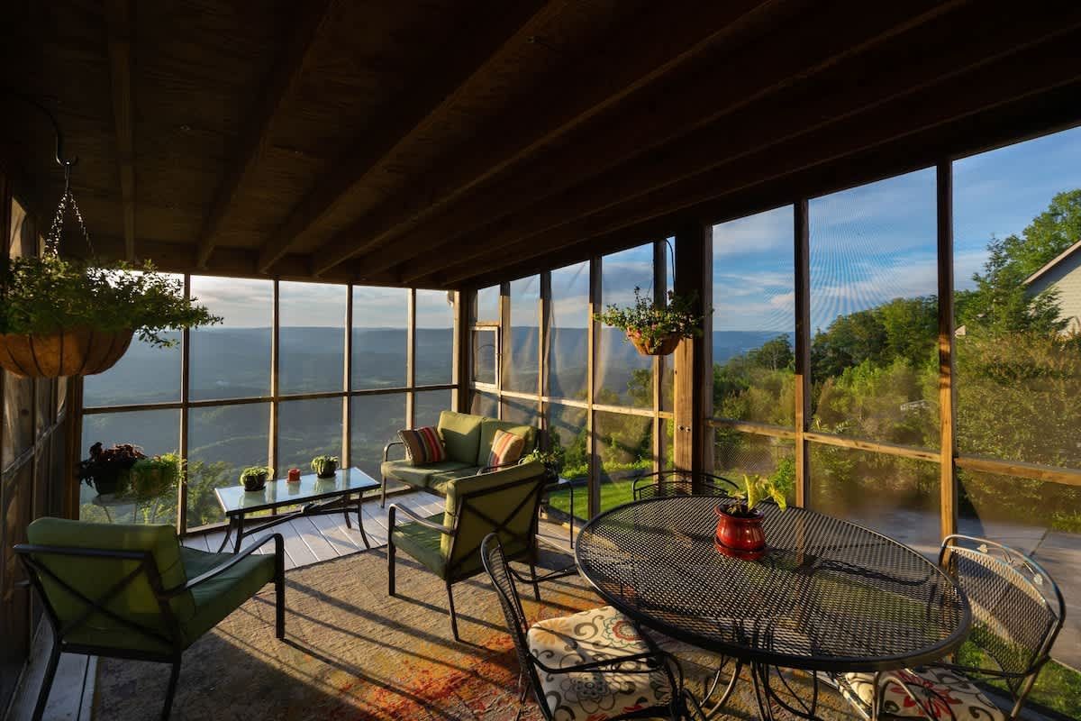 Screened porch with a table overlooking the valley