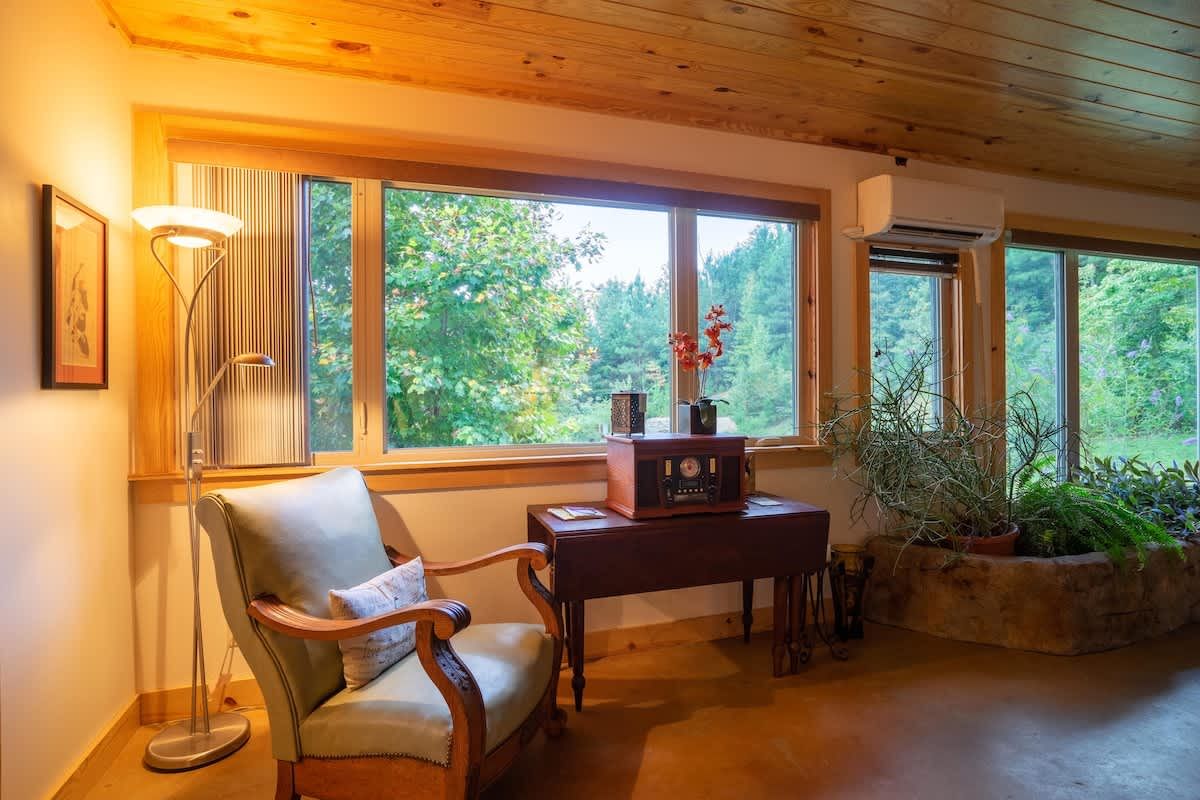 Reading chair by a wide window looking out at the trees