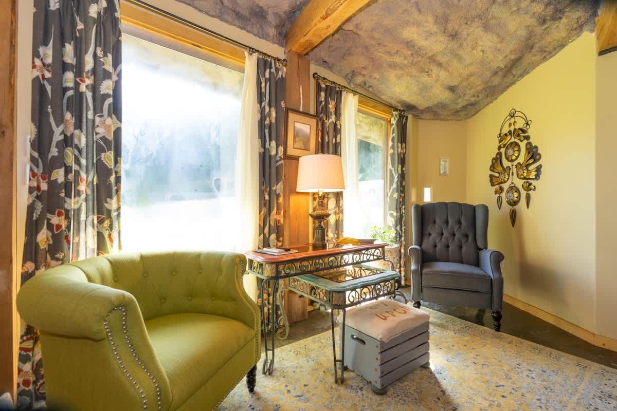 Sitting room with a green armchair and big windows
