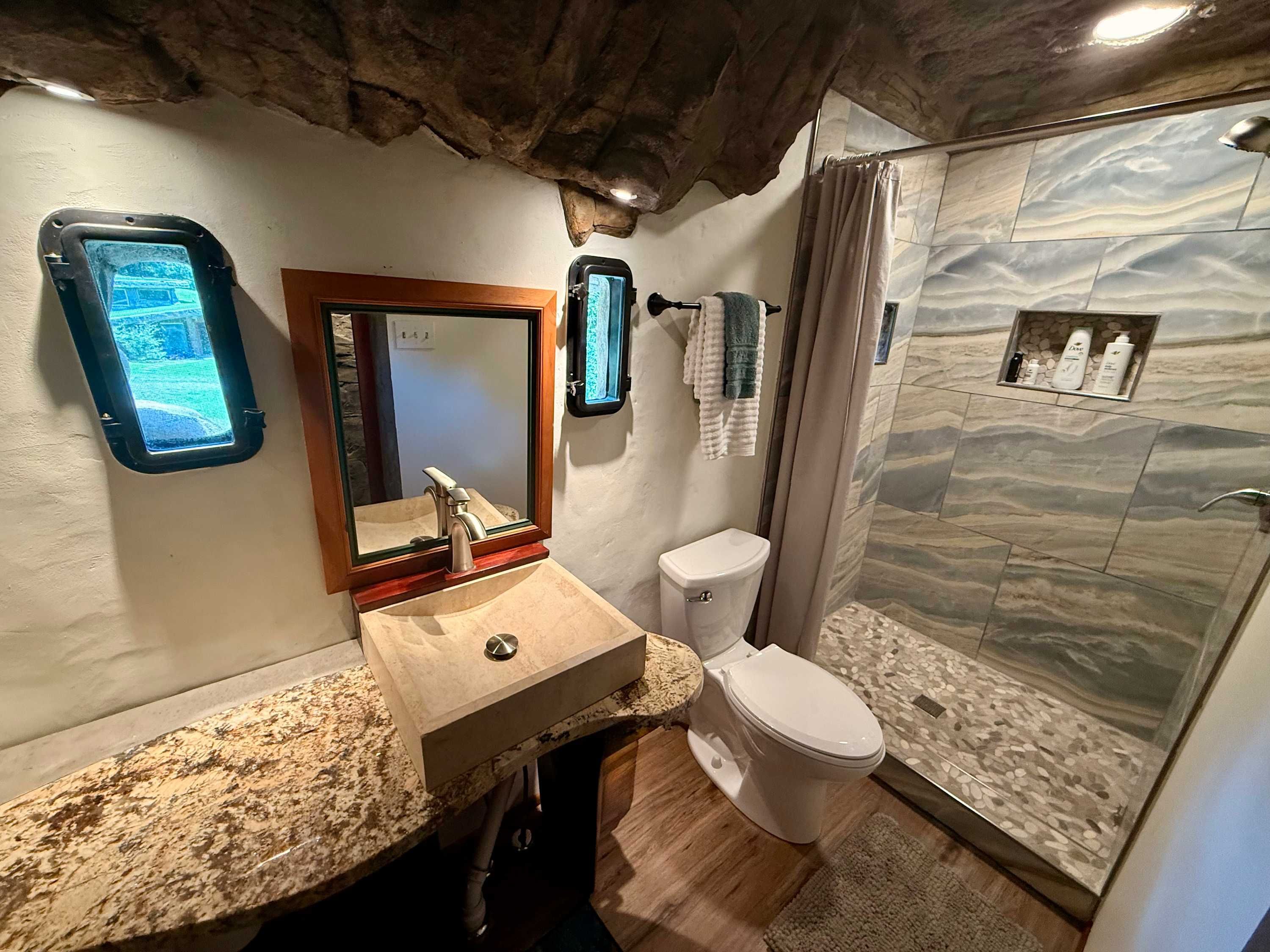 Bathroom with a stone shower and porthole windows