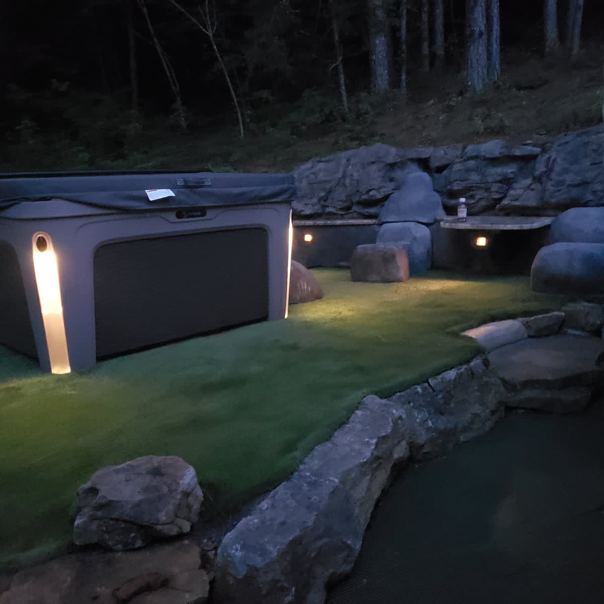 Hot tub on a lawn among the boulders
