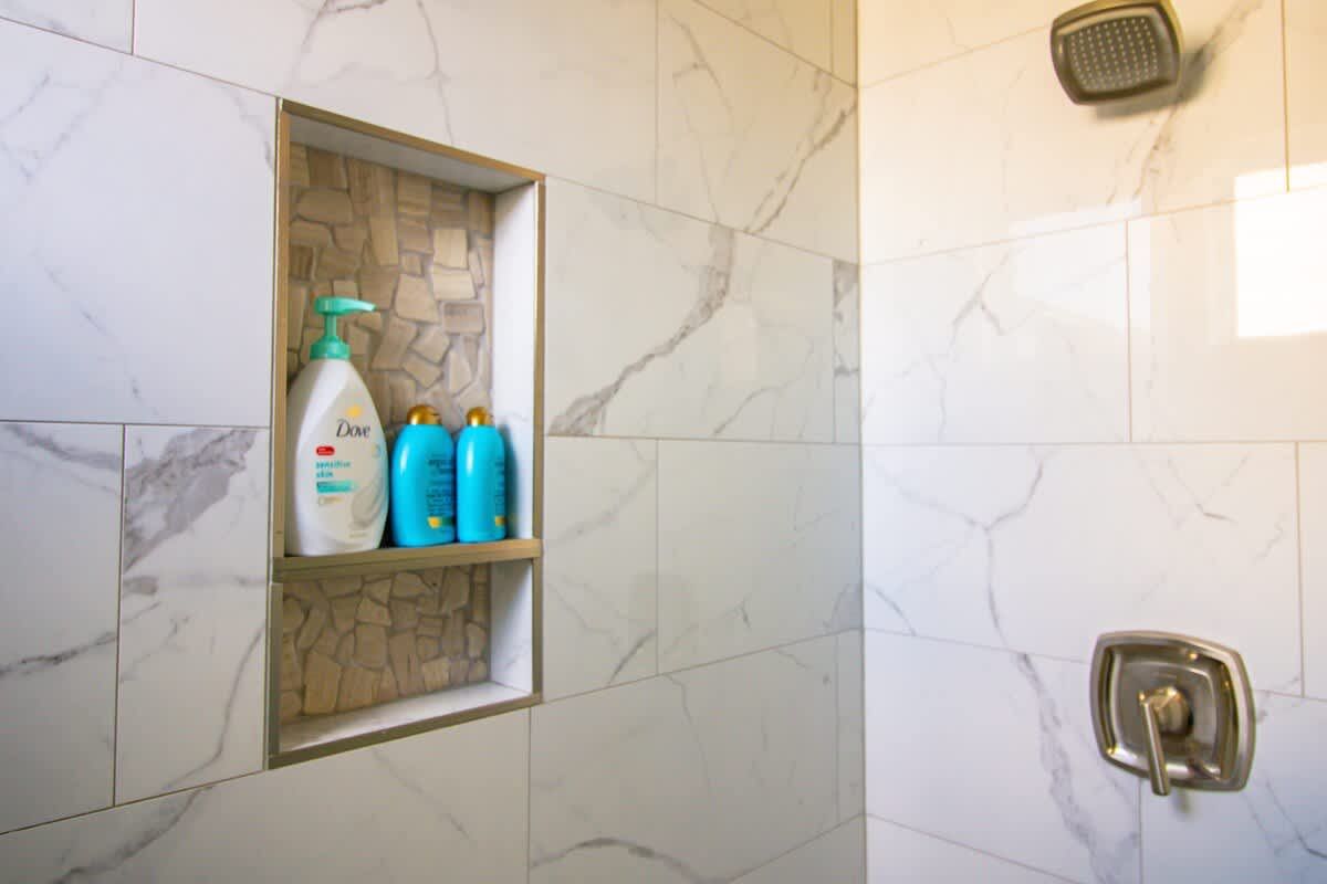 Marble-tiled shower in an en suite bathroom