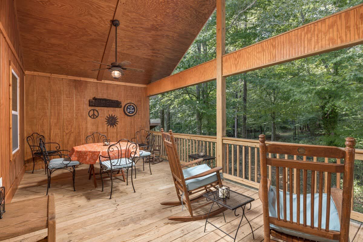 Covered porch with a table and rocking chairs