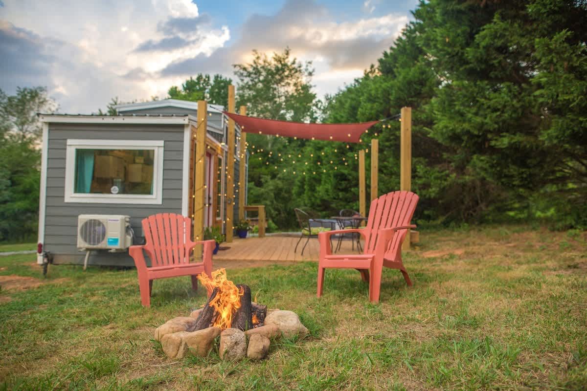Red Adirondack chairs around a fire pit