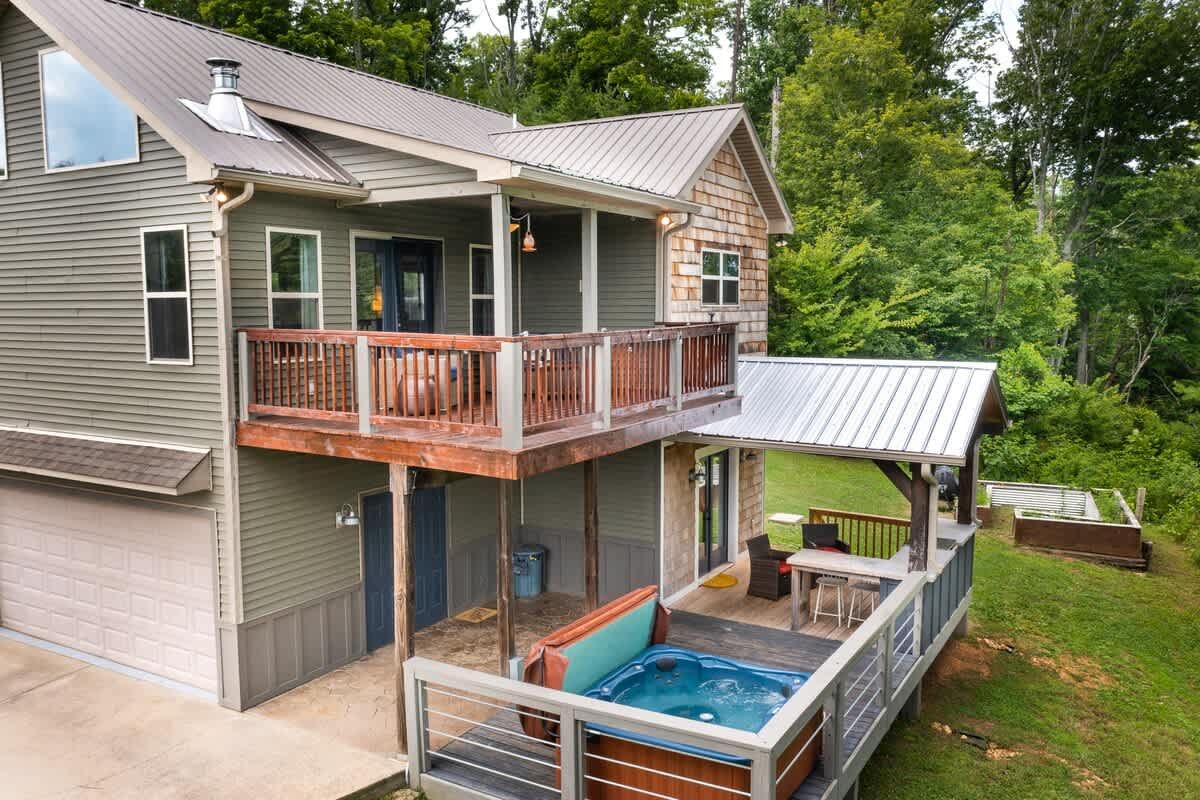 The two-story farmhouse with its decks and hot tub